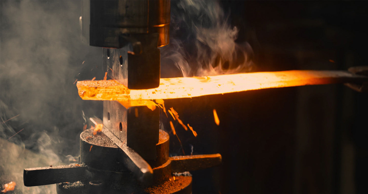 Hot metal in power hammer dies, forging metal art.